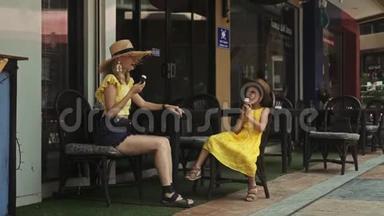 母亲和女儿在<strong>夏日</strong>的街头咖啡馆吃<strong>冰淇淋</strong>